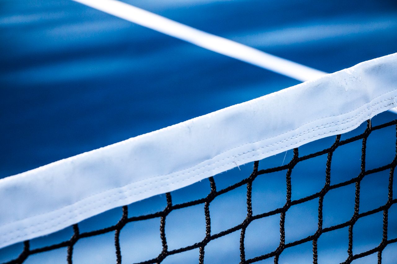 Mastering the First Impression: Your intriguing post title goes here Sharp close-up of a tennis net with a blue court in the background, perfect for sports-themed designs.